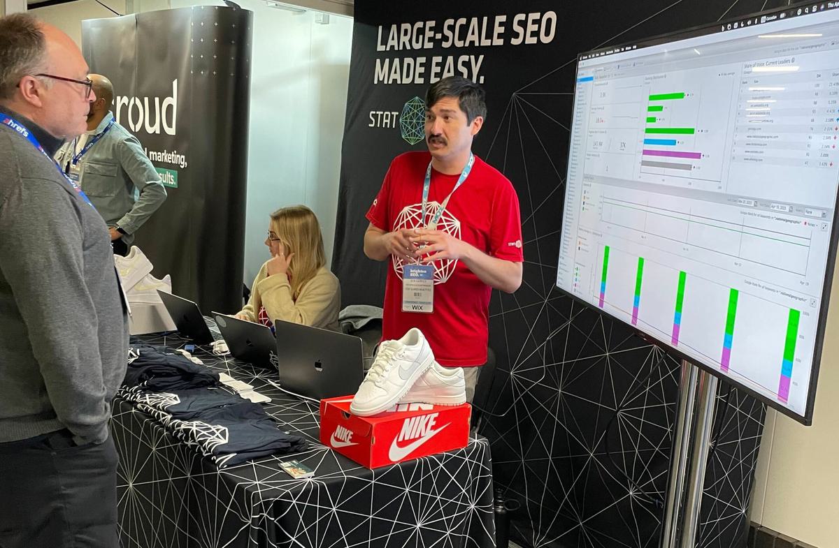 A picture of a friendly STAT employee greeting conference-goers.