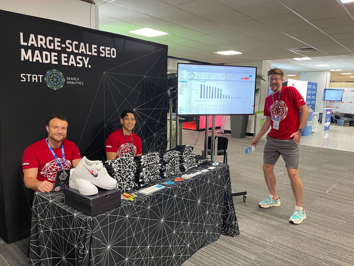 A photo of the STAT team manning a both with a demo screen, STAT t-shirts, and sneakers for a lucky draw winner.